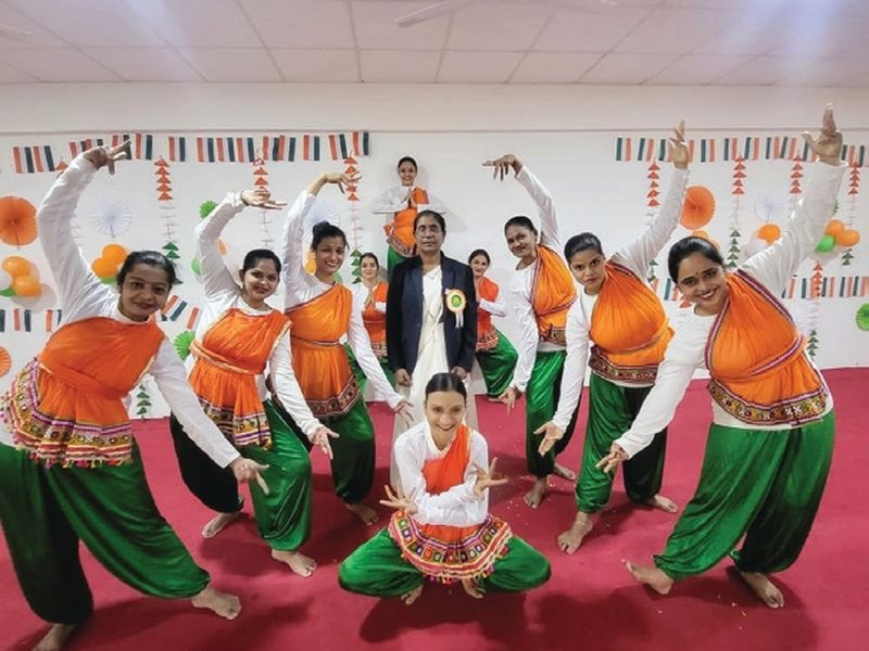 Students performing Indian cultural dance in tricolor costumes at SSPM event